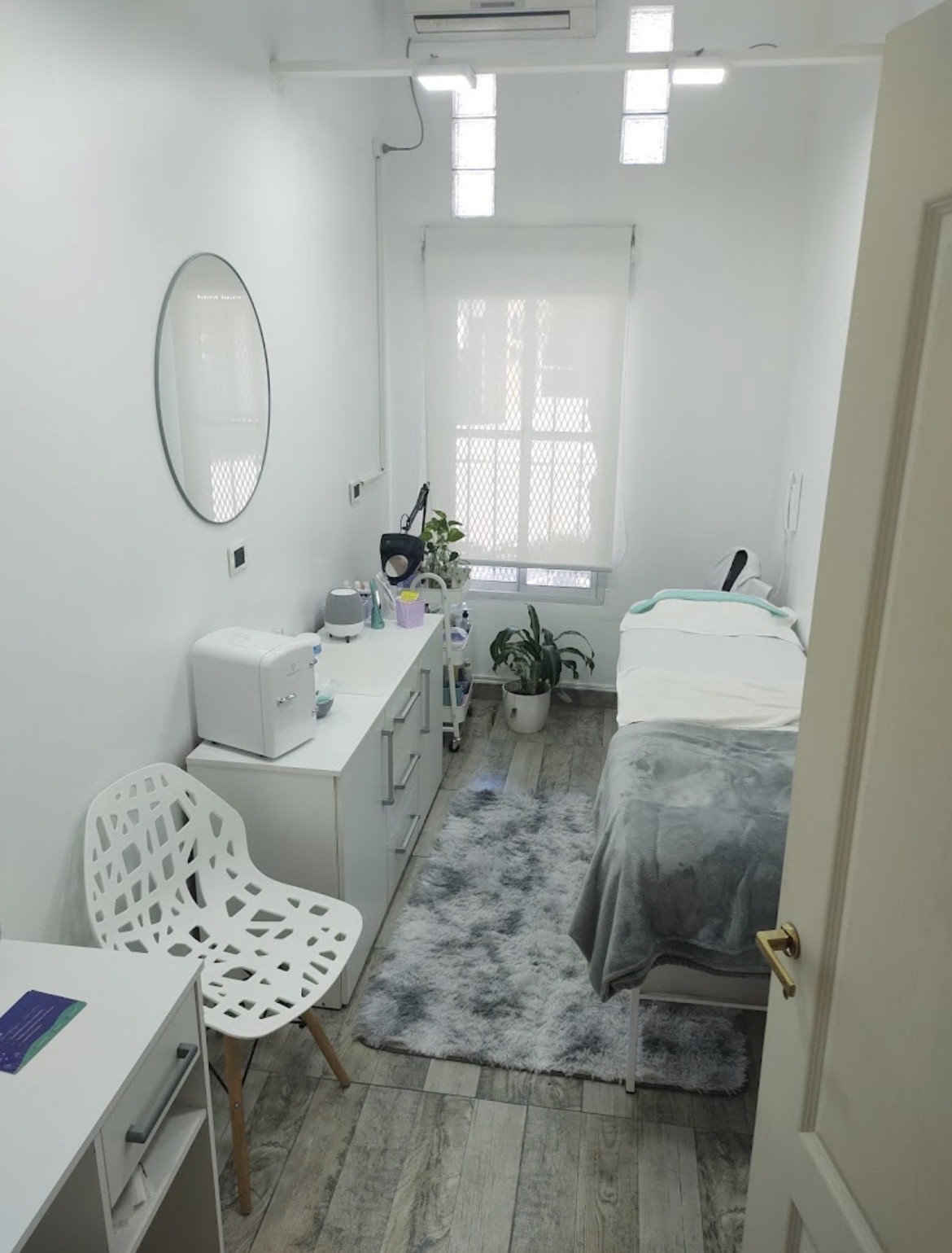 Modern high-end facial cosmiatria equipment in clean aesthetic clinic, ultrasonic spatula, dermapen, high frequency wand neatly displayed on marble tray with small lavender bouquet and cosmetic jars, soft pink ambient glow, warm bright luxury clinic Ituzaingo.